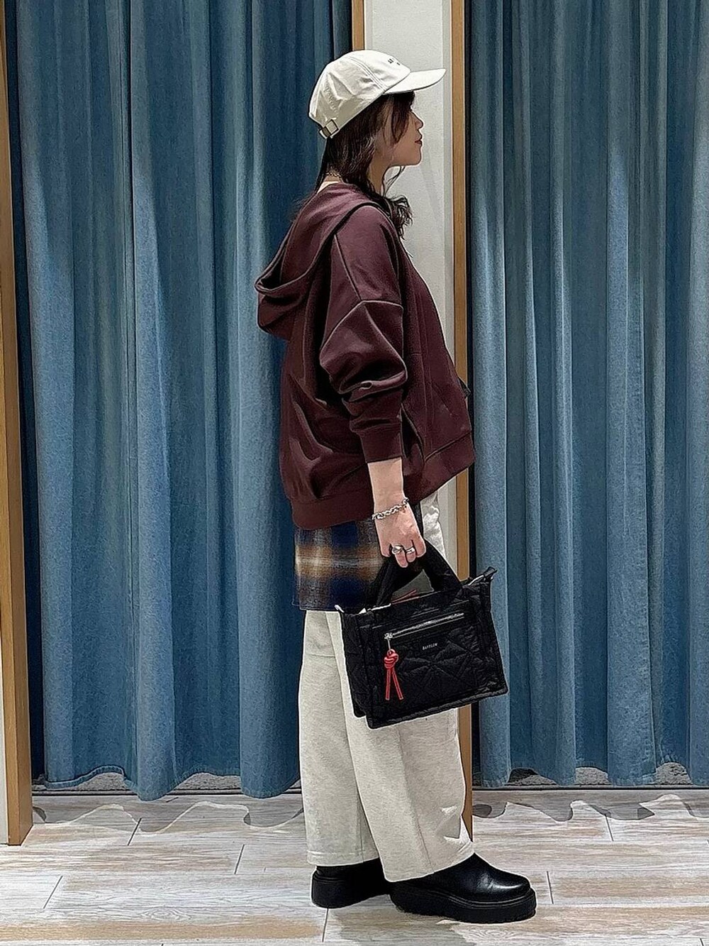 ブラック系のショルダーバッグ、ブラック系のブーツ、ブルー系のシャツ/ブラウスを着用したレディースの冬コーディネートの2枚目の写真