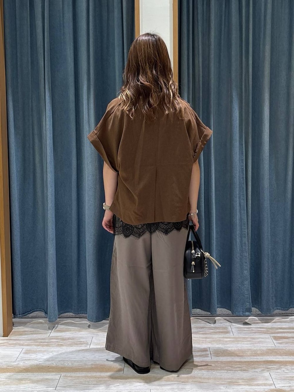 ブラウン系のその他パンツ、ブラック系のハンドバッグ、ブラック系のサンダルを着用したレディースの夏コーディネートの3枚目の写真