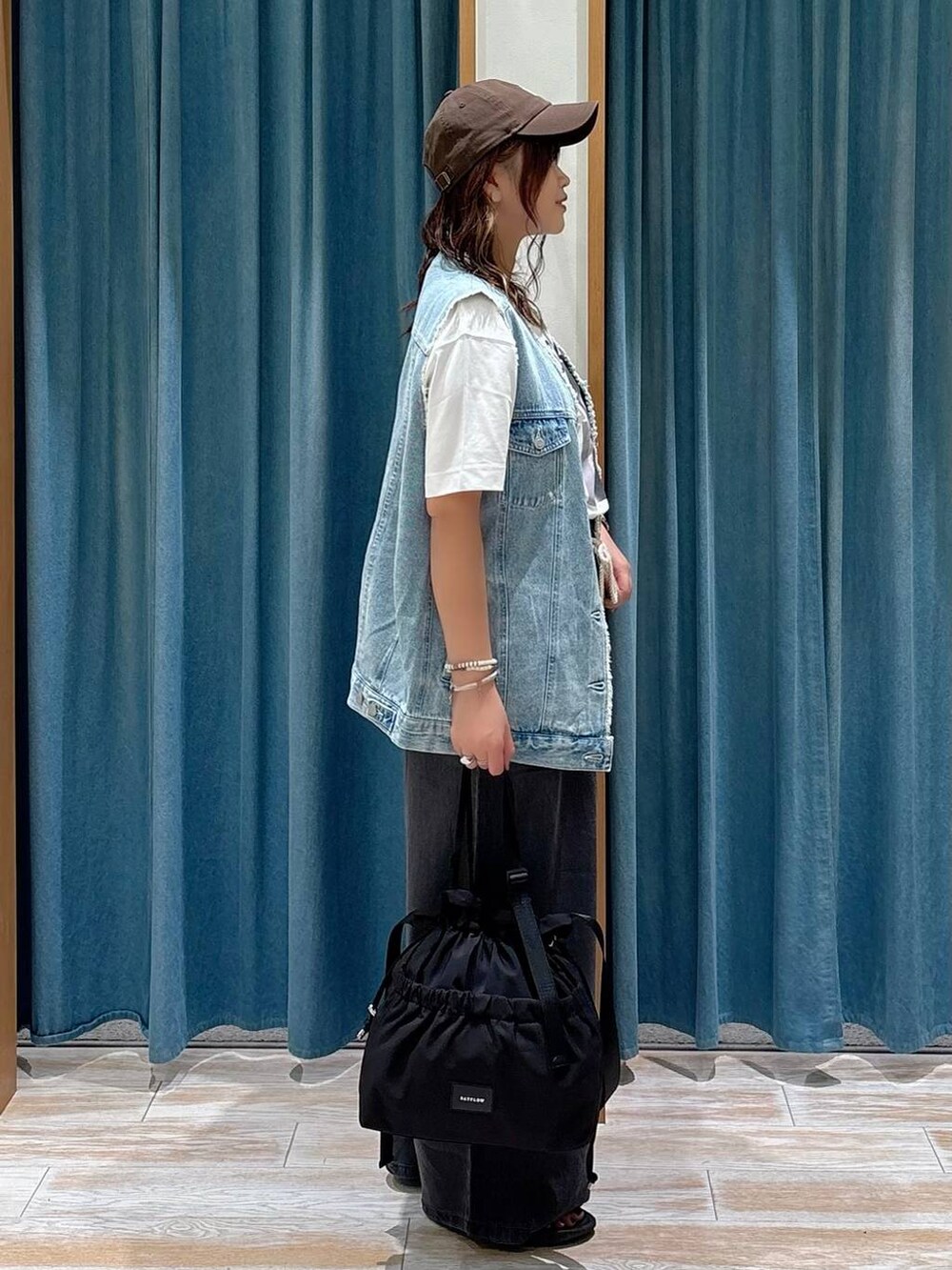 ブラック系のトートバッグ、ブラック系のその他パンツ、ホワイト系のTシャツ/カットソーを着用したレディースの夏コーディネートの2枚目の写真