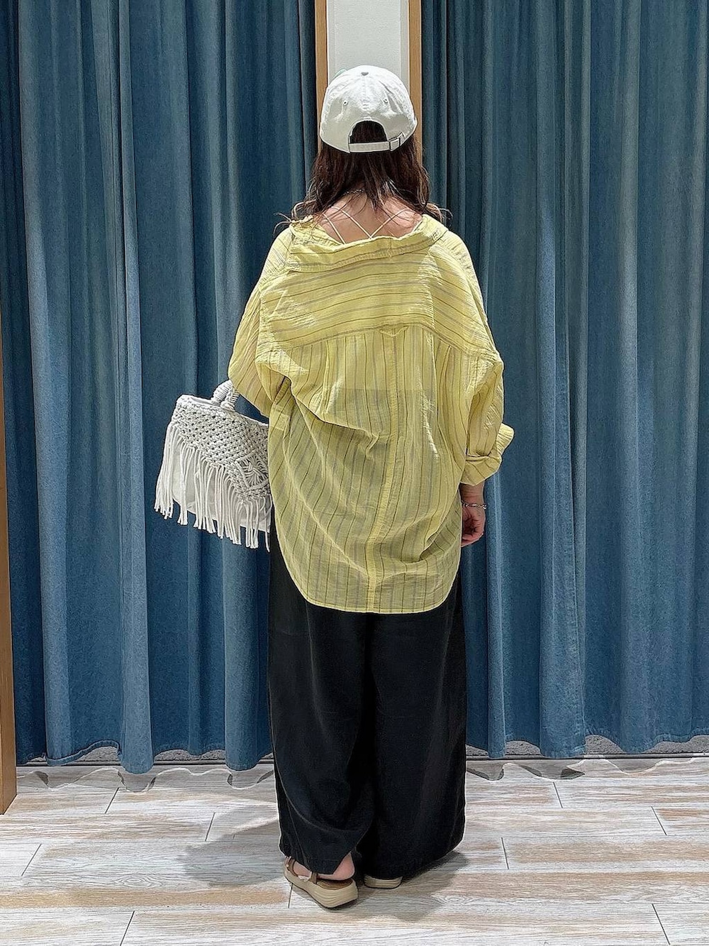 イエロー系のシャツ/ブラウス、グレー系のその他パンツ、ゴールド系のサンダルを着用したレディースの夏コーディネートの3枚目の写真
