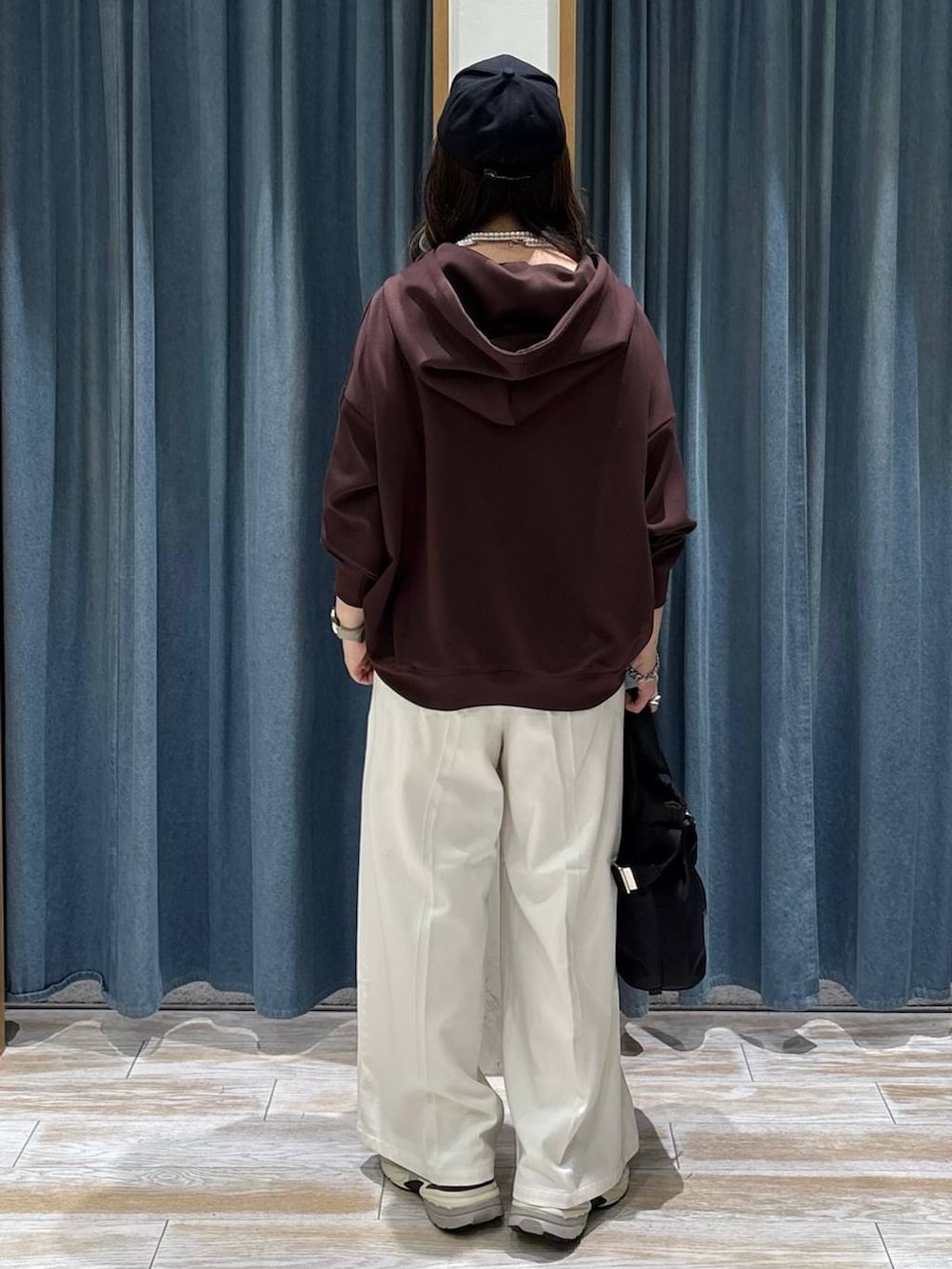 ブラック系のトートバッグ、ベージュ系のその他パンツ、ブラウン系のパーカーを着用したレディースの冬コーディネートの3枚目の写真