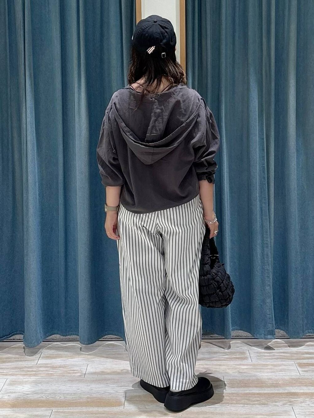 ブラック系のハンドバッグ、ブラック系のサンダル、ホワイト系のその他パンツを着用したレディースの秋コーディネートの3枚目の写真