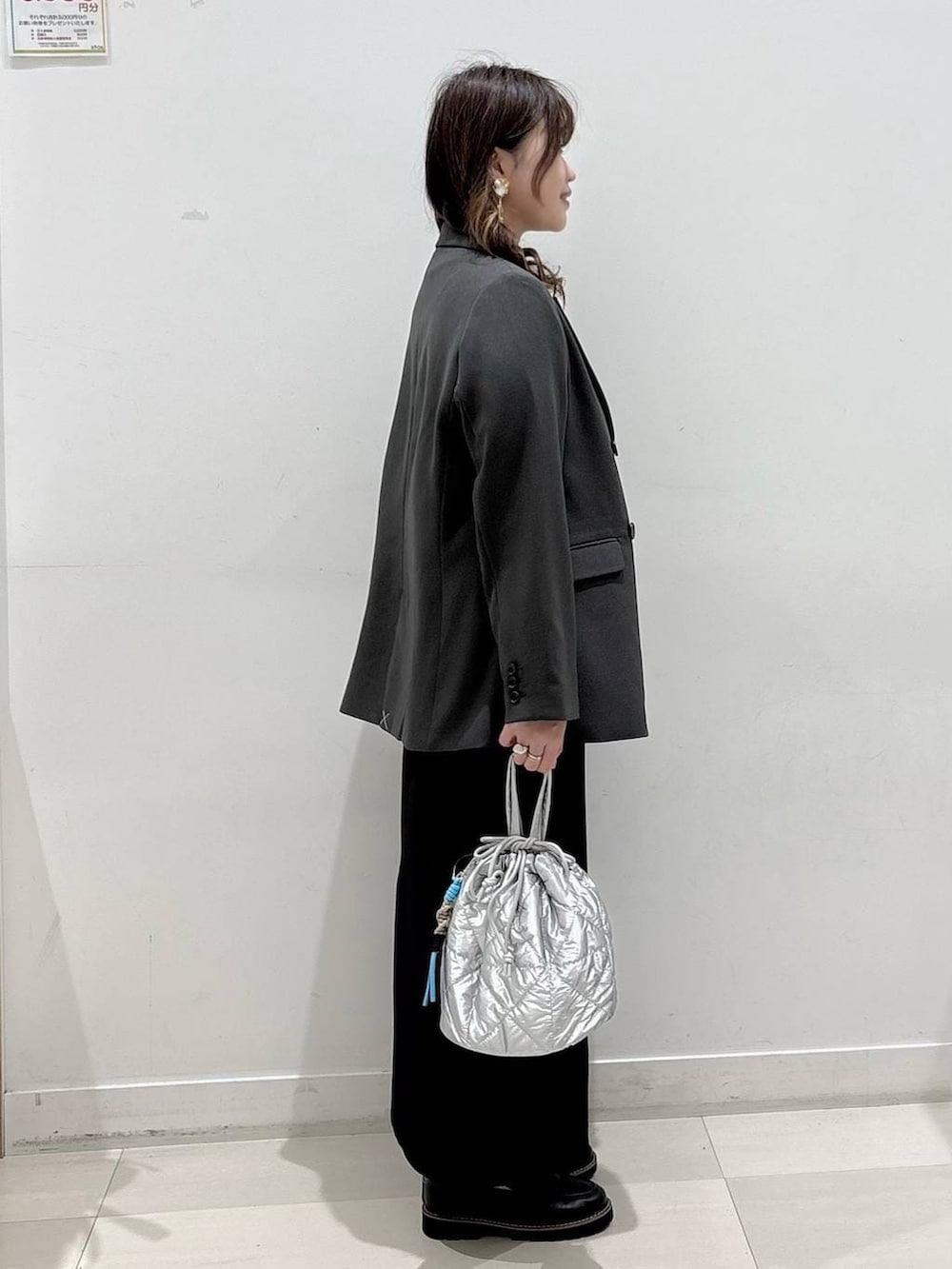 シルバー系のハンドバッグ、ブラック系のTシャツ/カットソー、ブラック系のスカートを着用したレディースの春コーディネートの2枚目の写真