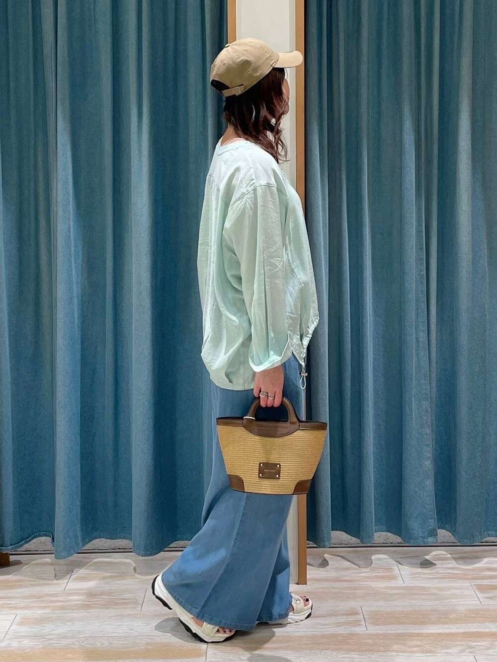 ブラウン系のショルダーバッグ、ブルー系のその他パンツ、グリーン系のシャツ/ブラウスを着用したレディースの春コーディネートの2枚目の写真