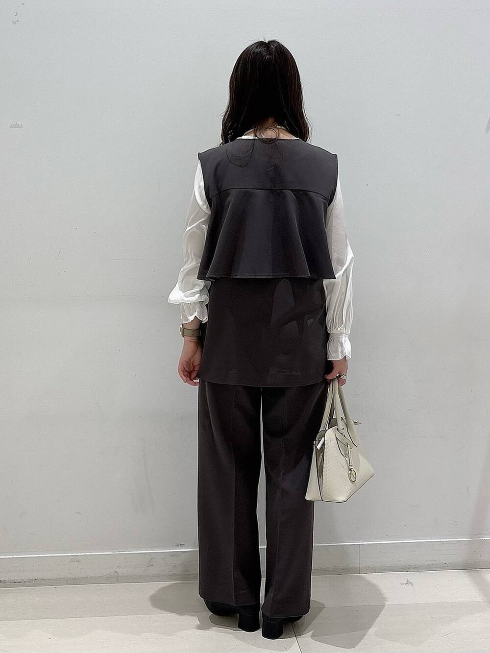 ブラック系のローファー、ホワイト系のショルダーバッグ、グレー系のセットアップを着用したレディースの冬コーディネートの3枚目の写真