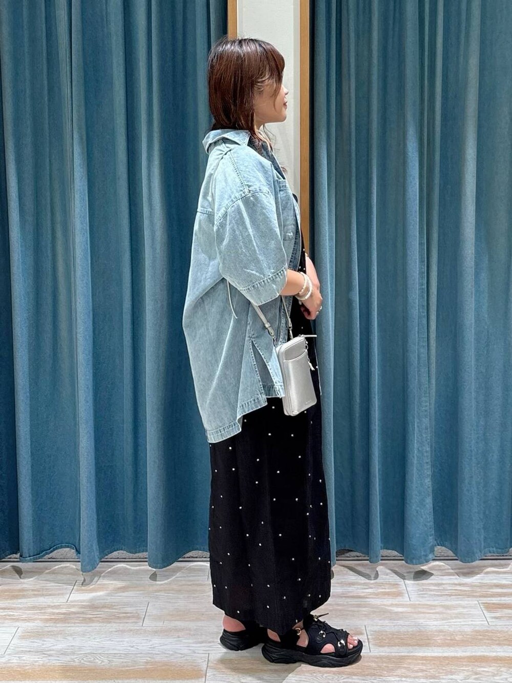 ブラック系のキャミソール、ブラック系のサンダル、ブルー系のシャツ/ブラウスを着用したレディースの夏コーディネートの2枚目の写真