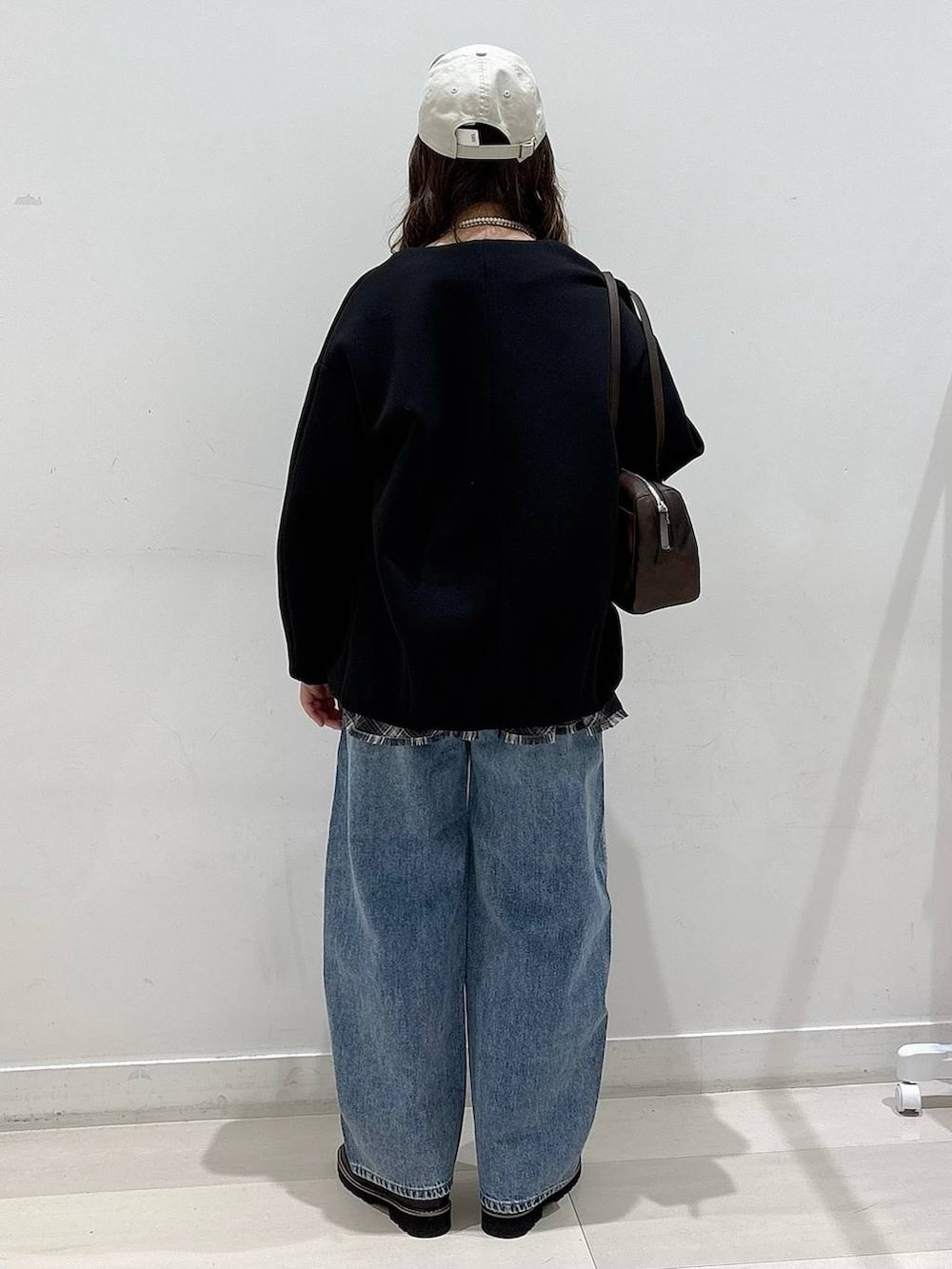 ブラック系のブルゾン、ブラック系のTシャツ/カットソー、ブルー系のデニムパンツを着用したレディースの春コーディネートの3枚目の写真