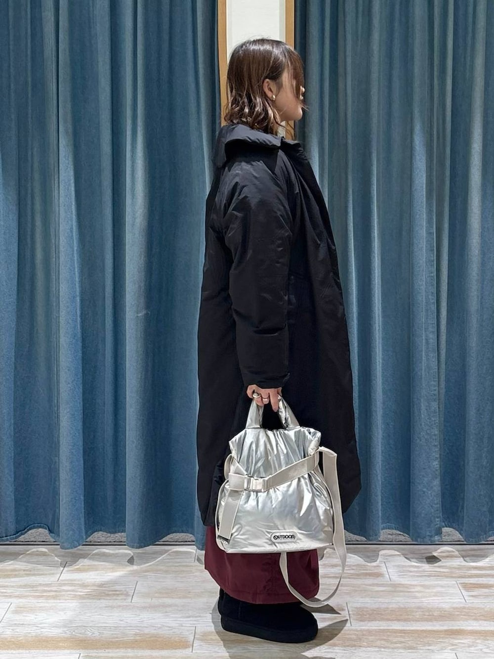 シルバー系のトートバッグ、レッド系のスカート、ブラック系のブーツを着用したレディースの秋コーディネートの2枚目の写真