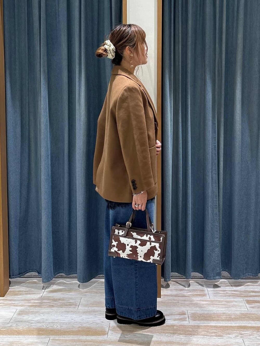 ブルー系のその他パンツ、その他のショルダーバッグ、ブラウン系のテーラードジャケットを着用したレディースの秋コーディネートの2枚目の写真