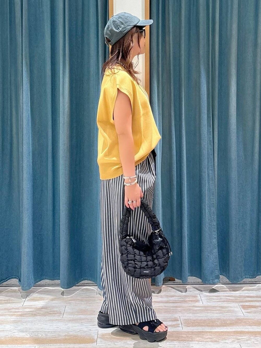 ブラック系のキャミソール、ブラック系のハンドバッグ、グレー系のその他パンツを着用したレディースの夏コーディネートの2枚目の写真