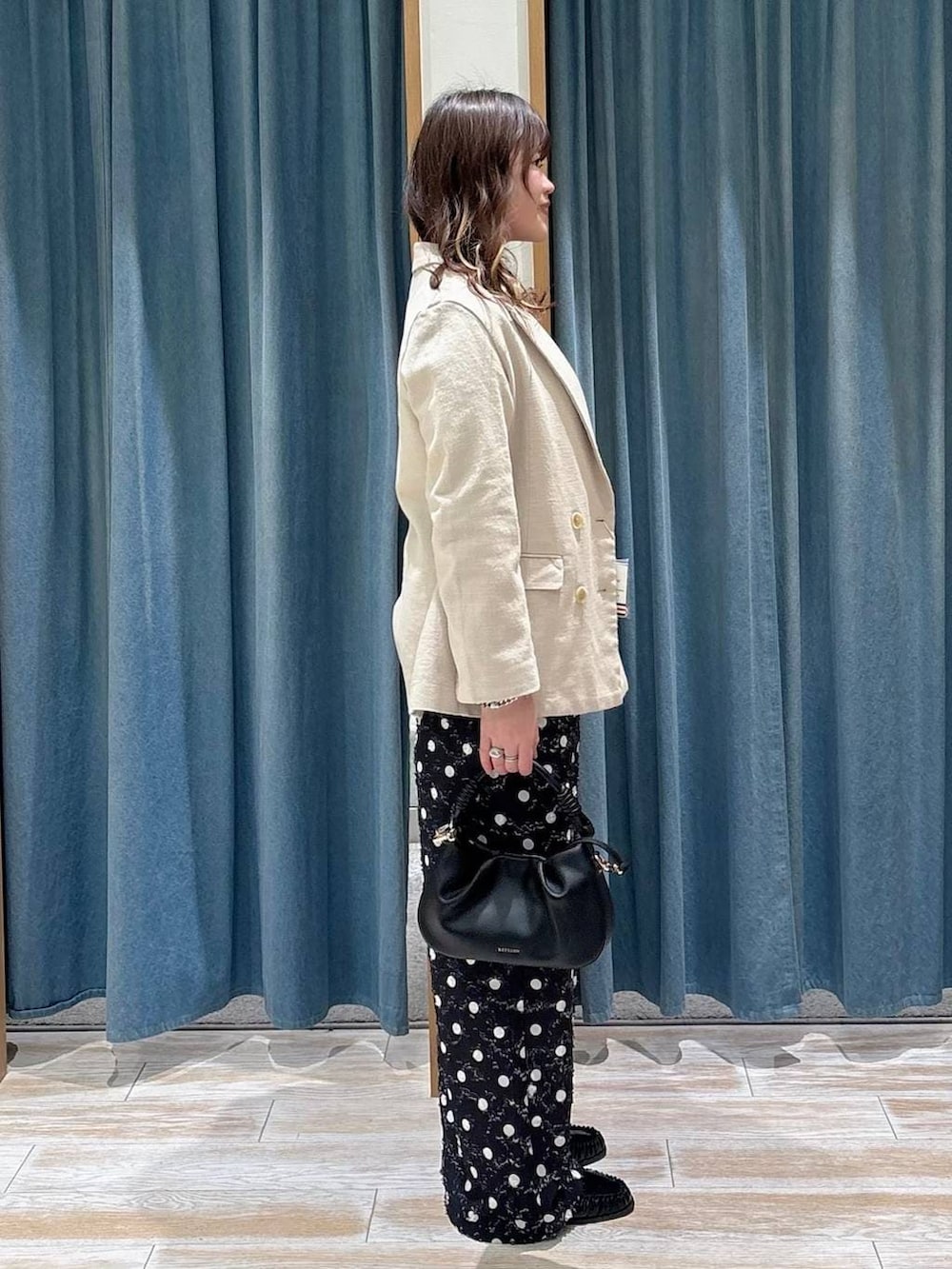 ブラック系のTシャツ/カットソー、ブラック系のハンドバッグ、ブラック系のローファーを着用したレディースの春コーディネートの2枚目の写真