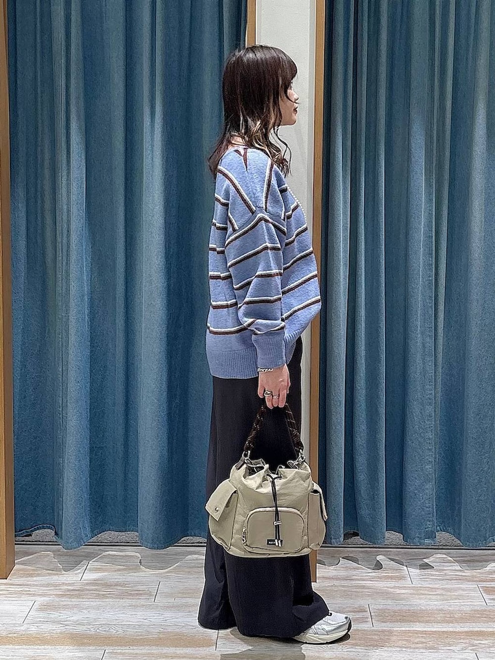 ベージュ系のハンドバッグ、ブルー系のニット/セーター、グレー系のその他パンツを着用したレディースの冬コーディネートの2枚目の写真