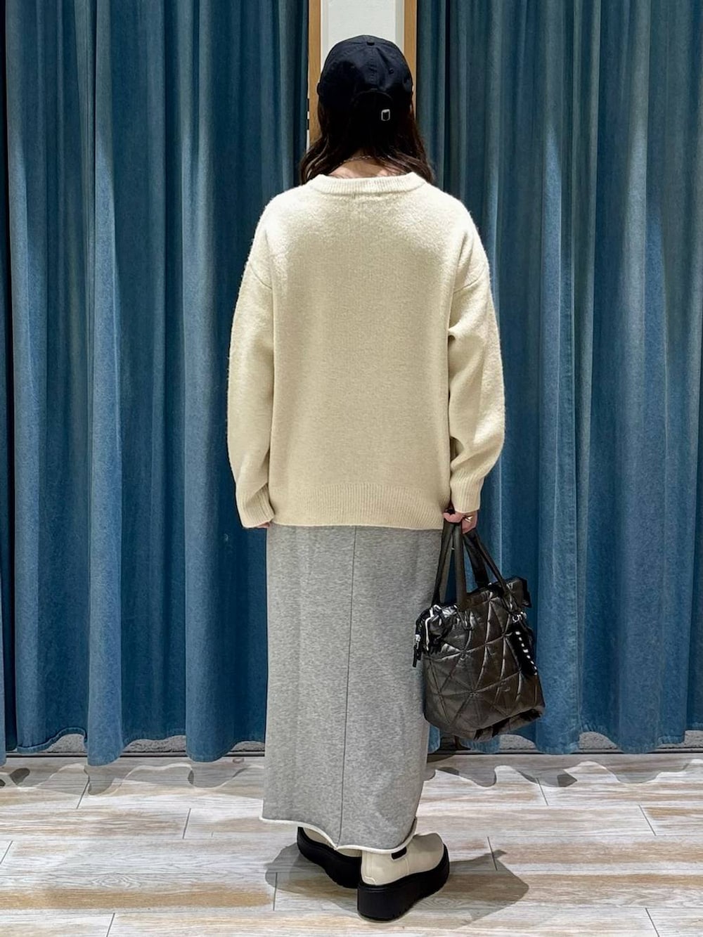 ベージュ系のブーツ、ホワイト系のニット/セーター、グレー系のスカートを着用したレディースの冬コーディネートの3枚目の写真