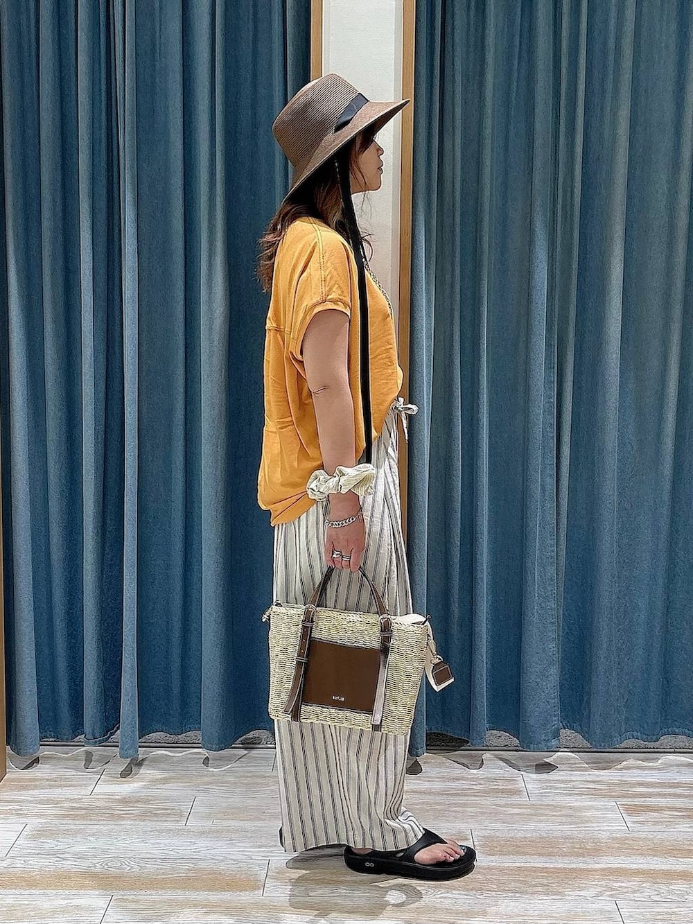 ホワイト系のその他パンツ、ブラウン系のショルダーバッグ、ブラック系のサンダルを着用したレディースの春コーディネートの2枚目の写真