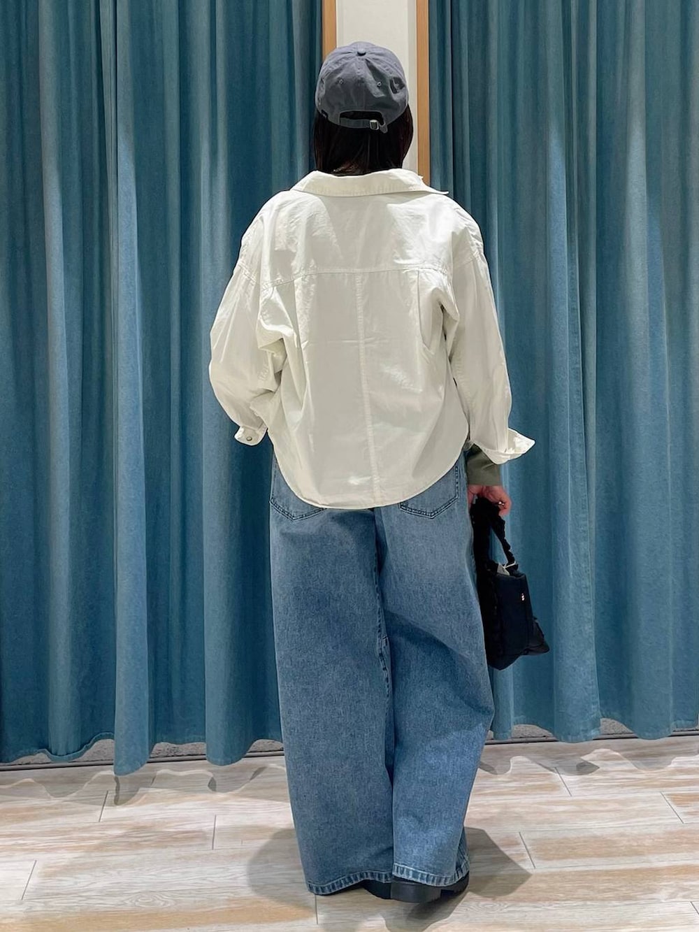 ブラック系のトートバッグ、ブルー系のデニムパンツ、その他のローファーを着用したレディースの冬コーディネートの3枚目の写真