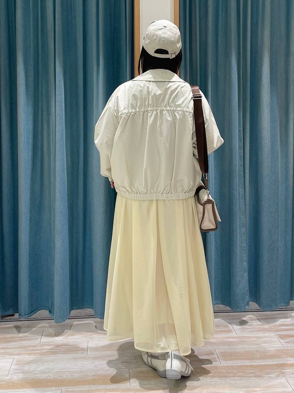 ホワイト系のTシャツ/カットソー、ベージュ系のショルダーバッグ、ホワイト系のスニーカーを着用したレディースの冬コーディネートの3枚目の写真