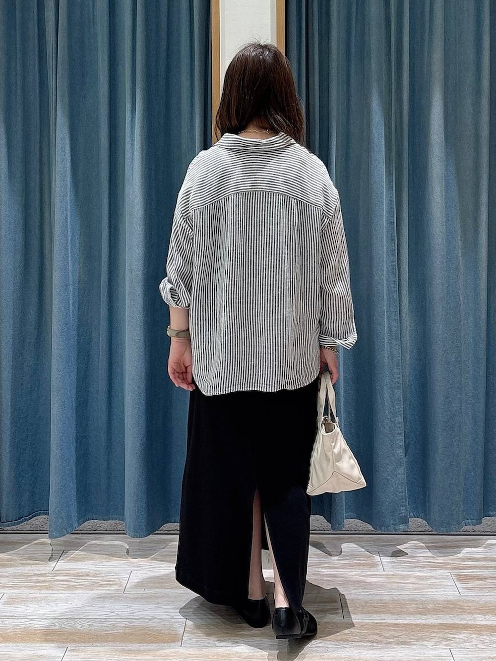 ブルー系のシャツ/ブラウス、ホワイト系のトートバッグ、ブラック系のパンプスを着用したレディースの春コーディネートの3枚目の写真