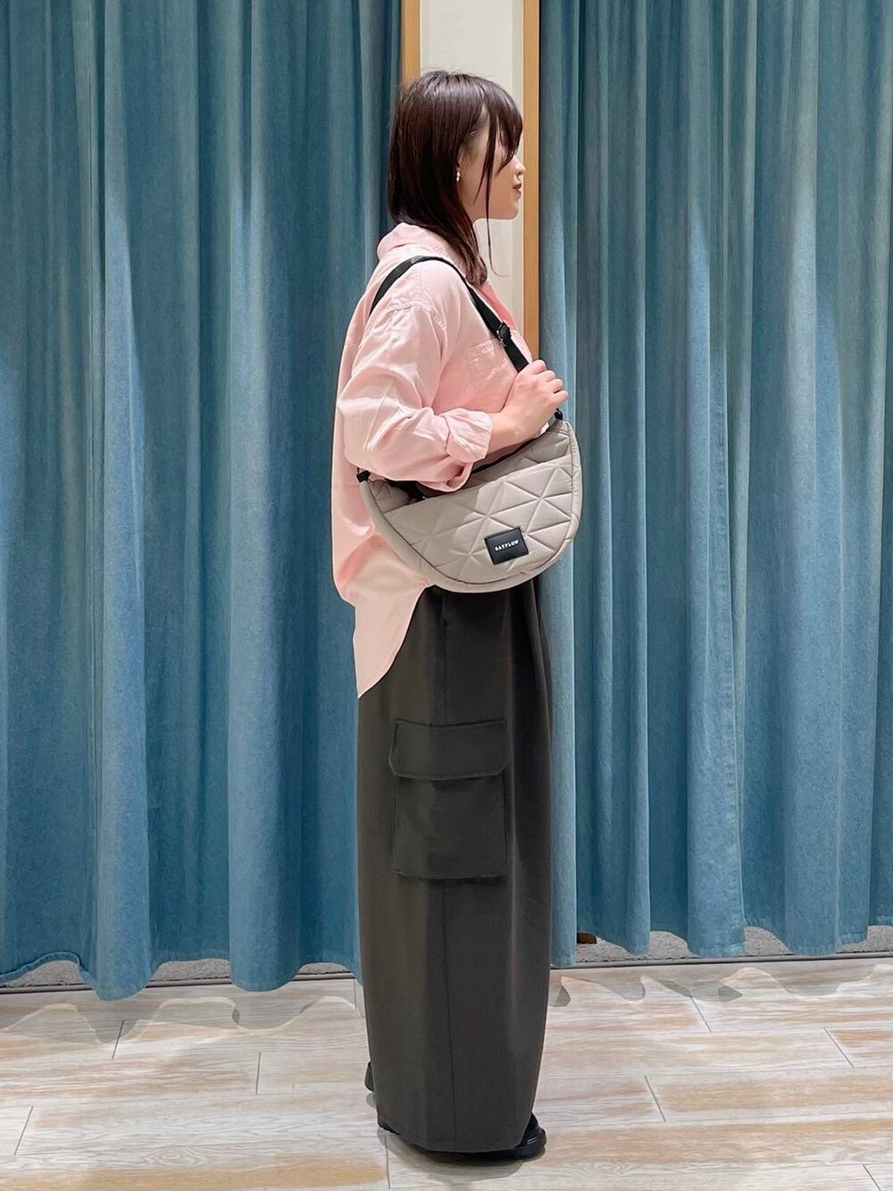 ピンク系のシャツ/ブラウス、ベージュ系のショルダーバッグ、その他のローファーを着用したレディースの冬コーディネートの2枚目の写真