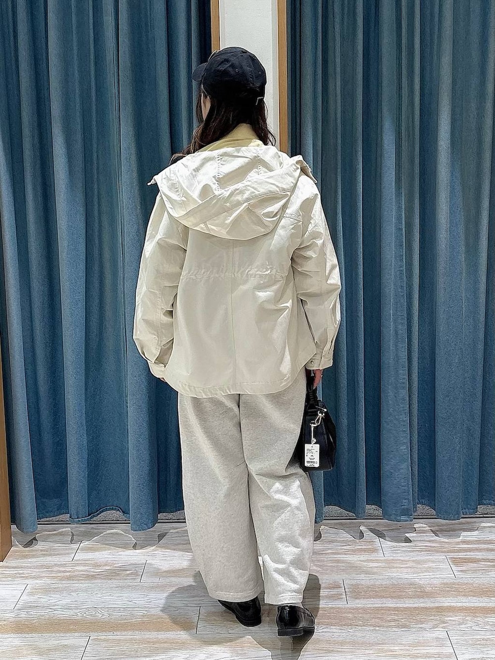 イエロー系のシャツ/ブラウス、ホワイト系のマウンテンパーカー、ブラック系のハンドバッグを着用したレディースの春コーディネートの3枚目の写真