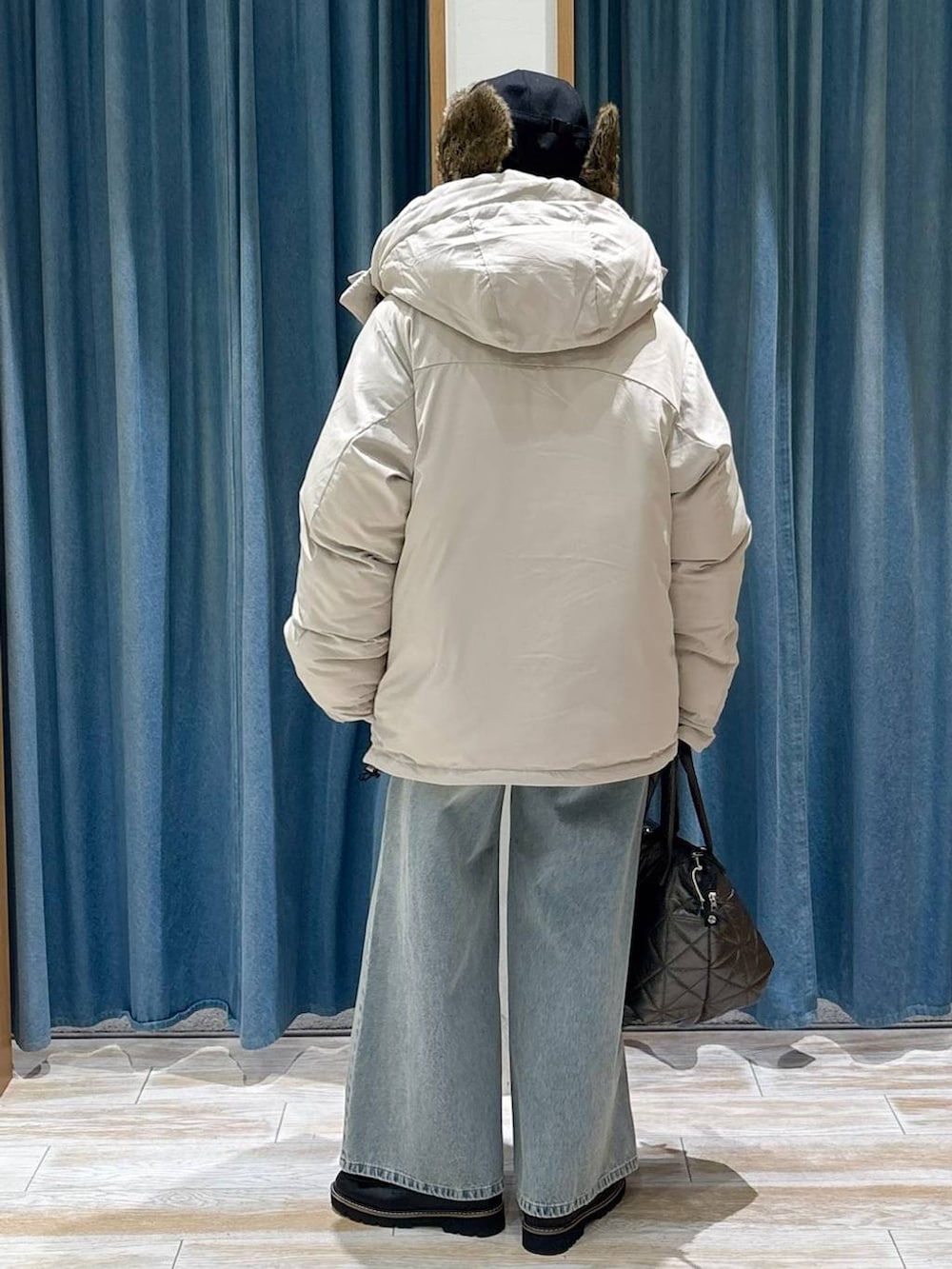 ブラック系のローファー、ベージュ系のダウンジャケット/コート、ブルー系のデニムパンツを着用したレディースの冬コーディネートの3枚目の写真