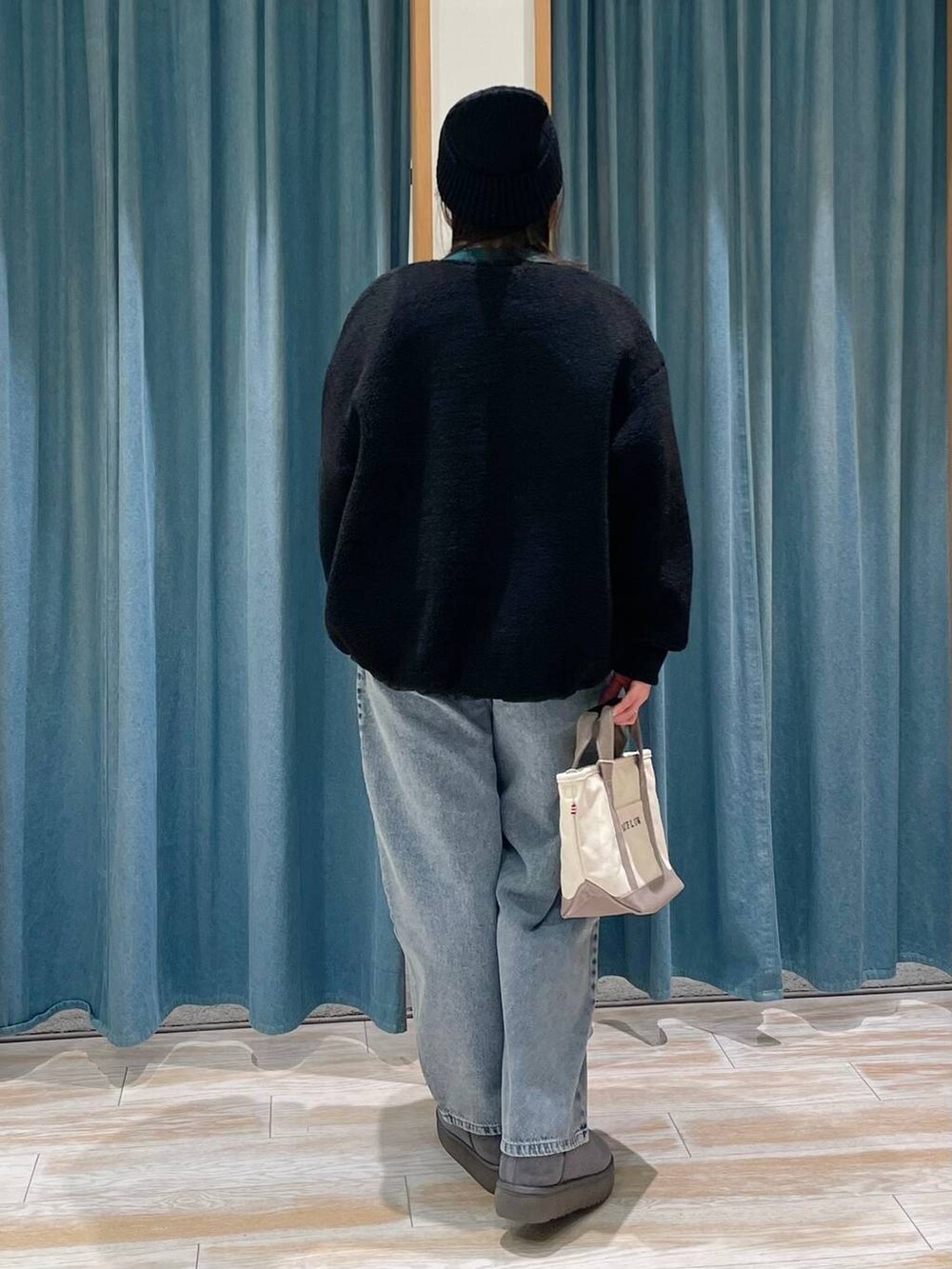 ブラック系のブルゾン、グレー系のトートバッグ、グリーン系のTシャツ/カットソーを着用したレディースの冬コーディネートの3枚目の写真