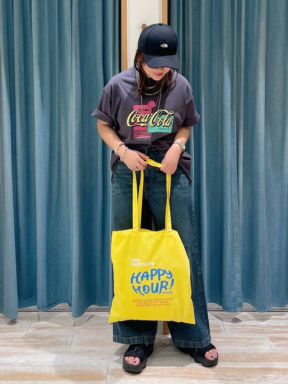 ブルー系のデニムパンツ、イエロー系のトートバッグ、グレー系のTシャツ/カットソーを着用したレディースの夏コーディネートの4枚目の写真