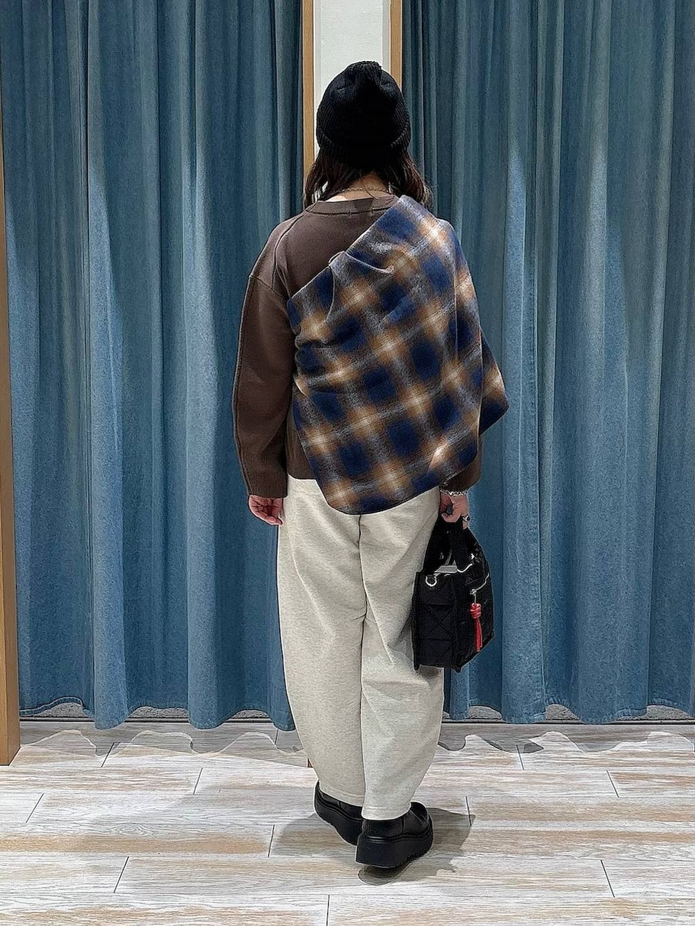 ブラック系のショルダーバッグ、ブラック系のブーツ、ブラウン系のニット/セーターを着用したレディースの冬コーディネートの3枚目の写真