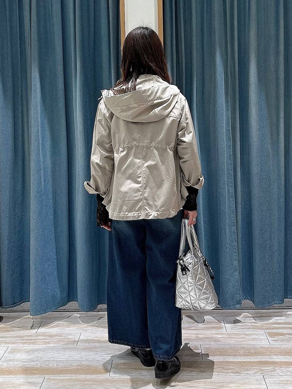 ブラック系のTシャツ/カットソー、ブルー系のデニムパンツ、ベージュ系のマウンテンパーカーを着用したレディースの春コーディネートの3枚目の写真