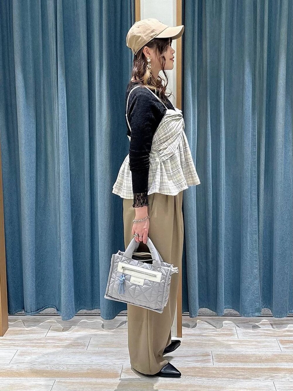 グレー系のショルダーバッグ、ブラック系のTシャツ/カットソー、ブラック系のパンプスを着用したレディースの春コーディネートの2枚目の写真