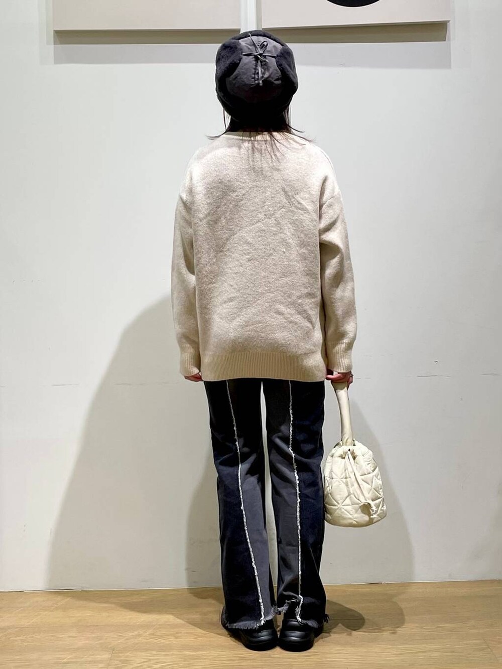 ブラック系のローファー、ベージュ系のショルダーバッグ、ブラック系のデニムパンツを着用したレディースの秋コーディネートの2枚目の写真