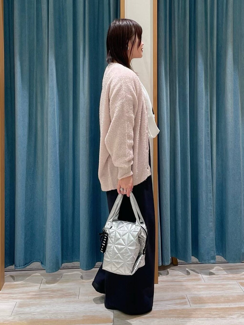 ブラック系のブーツ、ブラック系のその他パンツ、シルバー系のトートバッグを着用したレディースの冬コーディネートの2枚目の写真