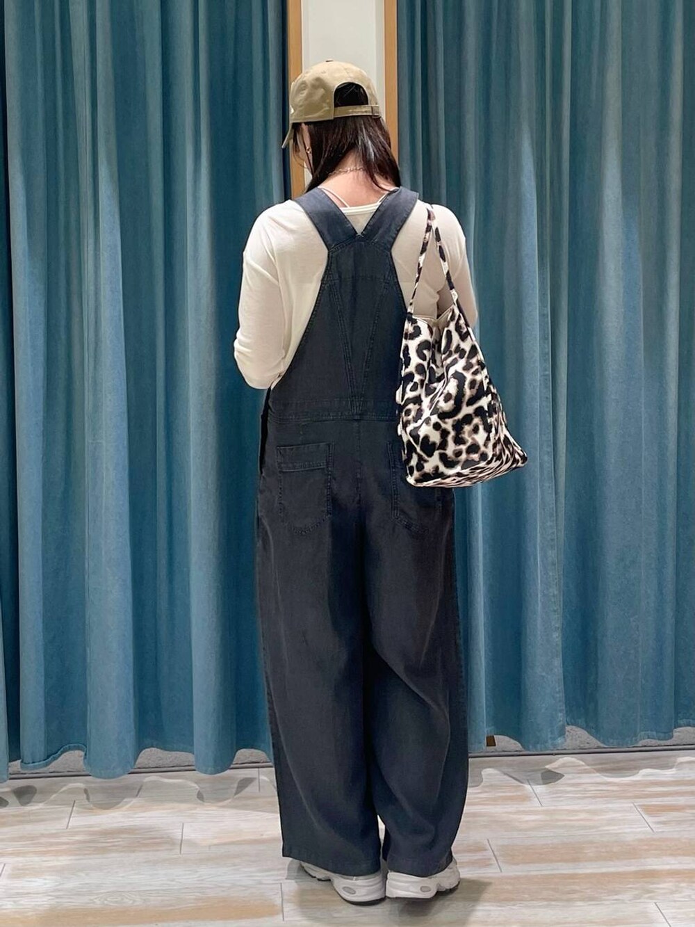 ベージュ系のトートバッグ、ホワイト系のTシャツ/カットソー、ベージュ系のキャップを着用したレディースの春コーディネートの3枚目の写真