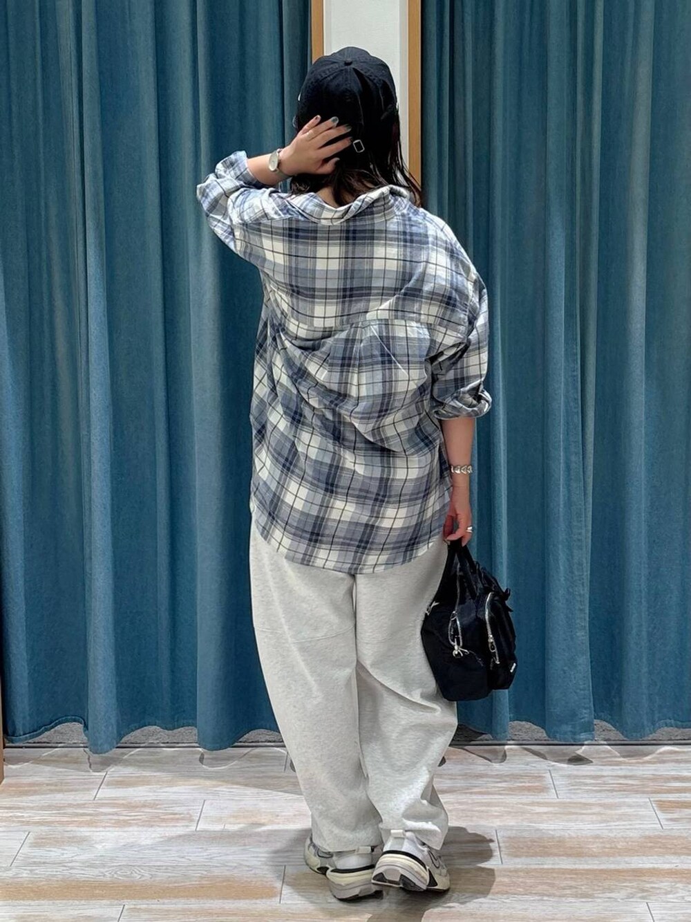 ブラック系のキャミソール、ブルー系のシャツ/ブラウス、ブラック系のハンドバッグを着用したレディースの秋コーディネートの3枚目の写真