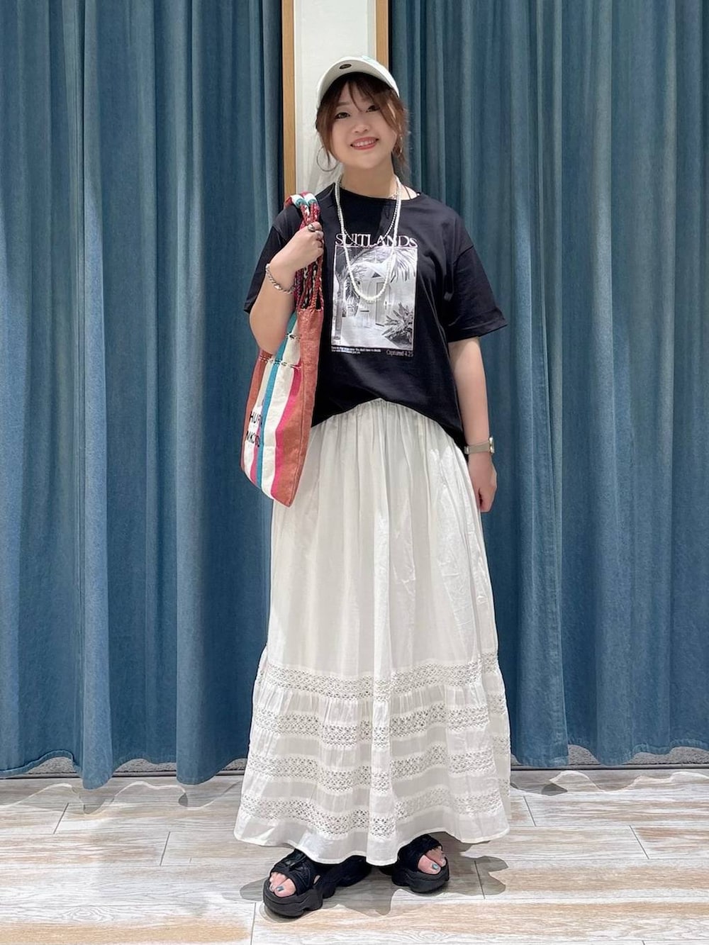 ホワイト系のスカート、ピンク系のトートバッグ、ブラック系のTシャツ/カットソーを着用したレディースの春コーディネートの4枚目の写真