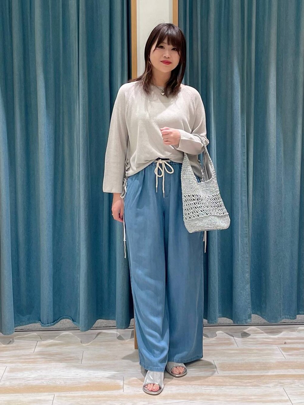 シルバー系のサンダル、グレー系のハンドバッグ、ブルー系のその他パンツを着用したレディースの春コーディネートの4枚目の写真