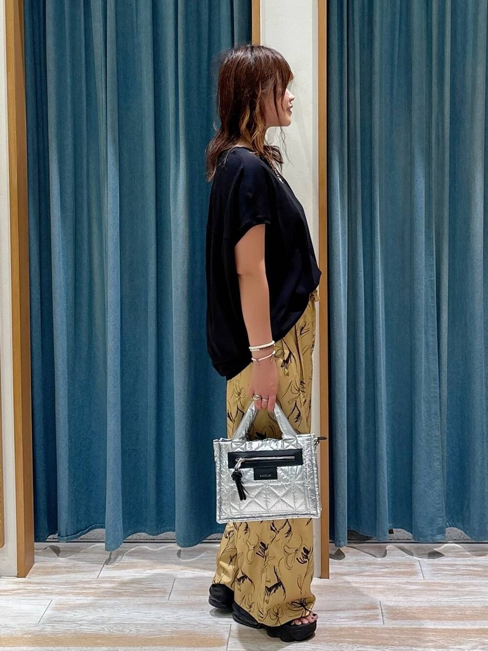 ブラック系のTシャツ/カットソー、シルバー系のショルダーバッグ、イエロー系のその他パンツを着用したレディースの夏コーディネートの2枚目の写真