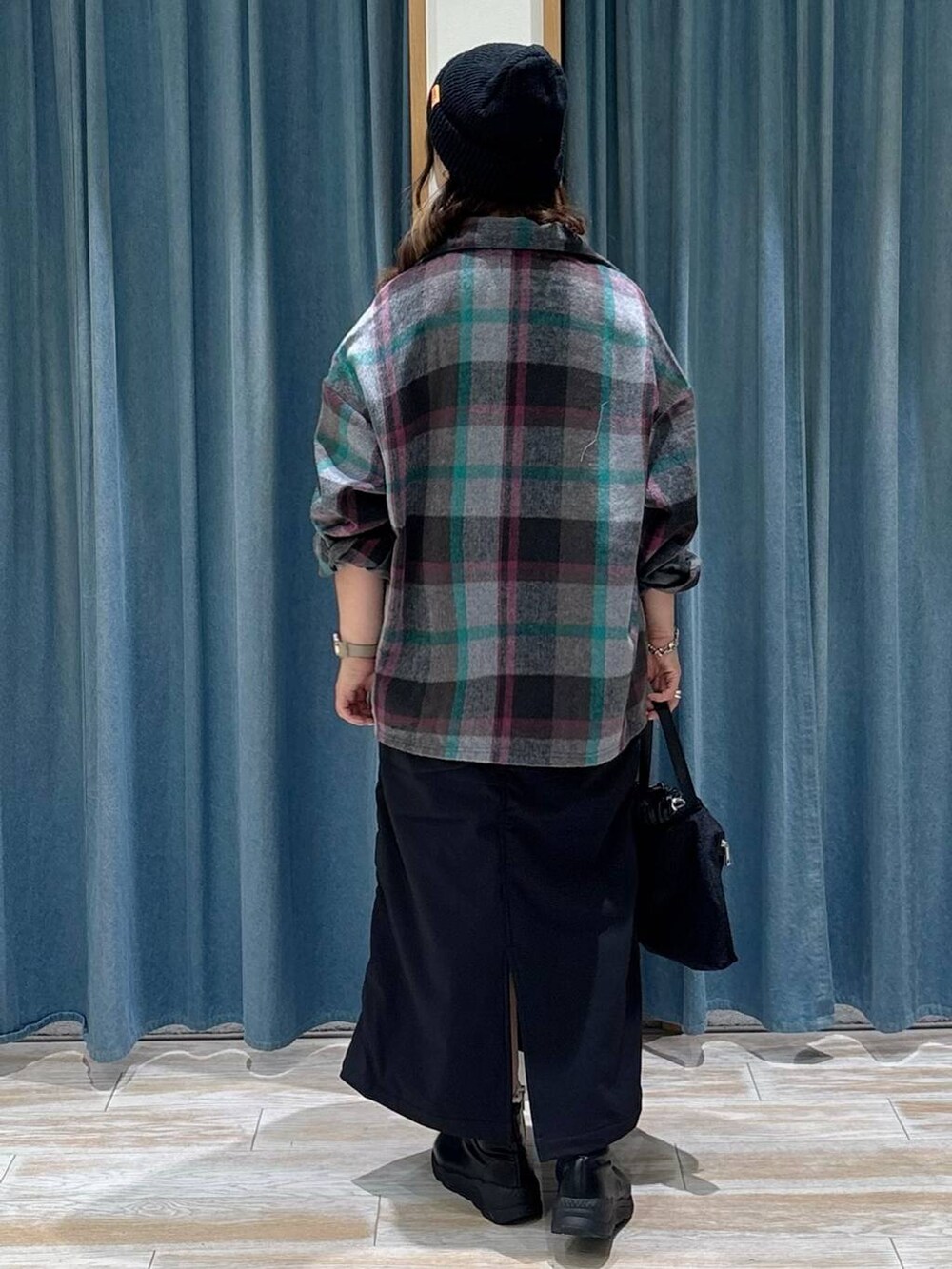 ブラック系のスカート、グレー系のその他アウター、ブラック系のブーツを着用したレディースの秋コーディネートの3枚目の写真