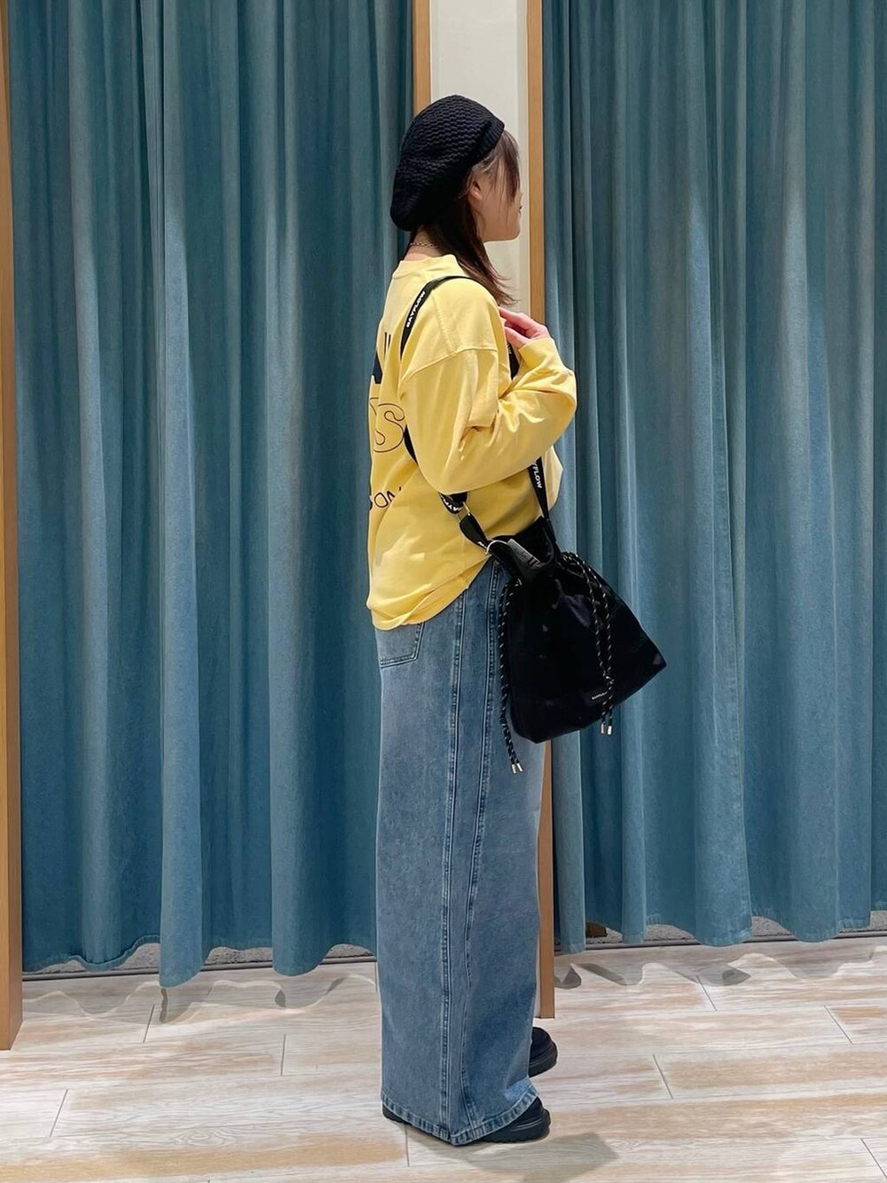 ブルー系のデニムパンツ、ブラック系のショルダーバッグ、その他のローファーを着用したレディースの冬コーディネートの2枚目の写真