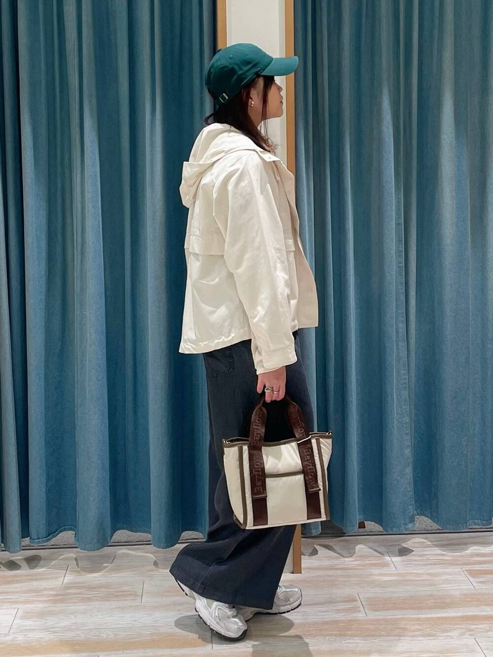 ホワイト系のマウンテンパーカー、ベージュ系のトートバッグ、ホワイト系のTシャツ/カットソーを着用したレディースの春コーディネートの2枚目の写真