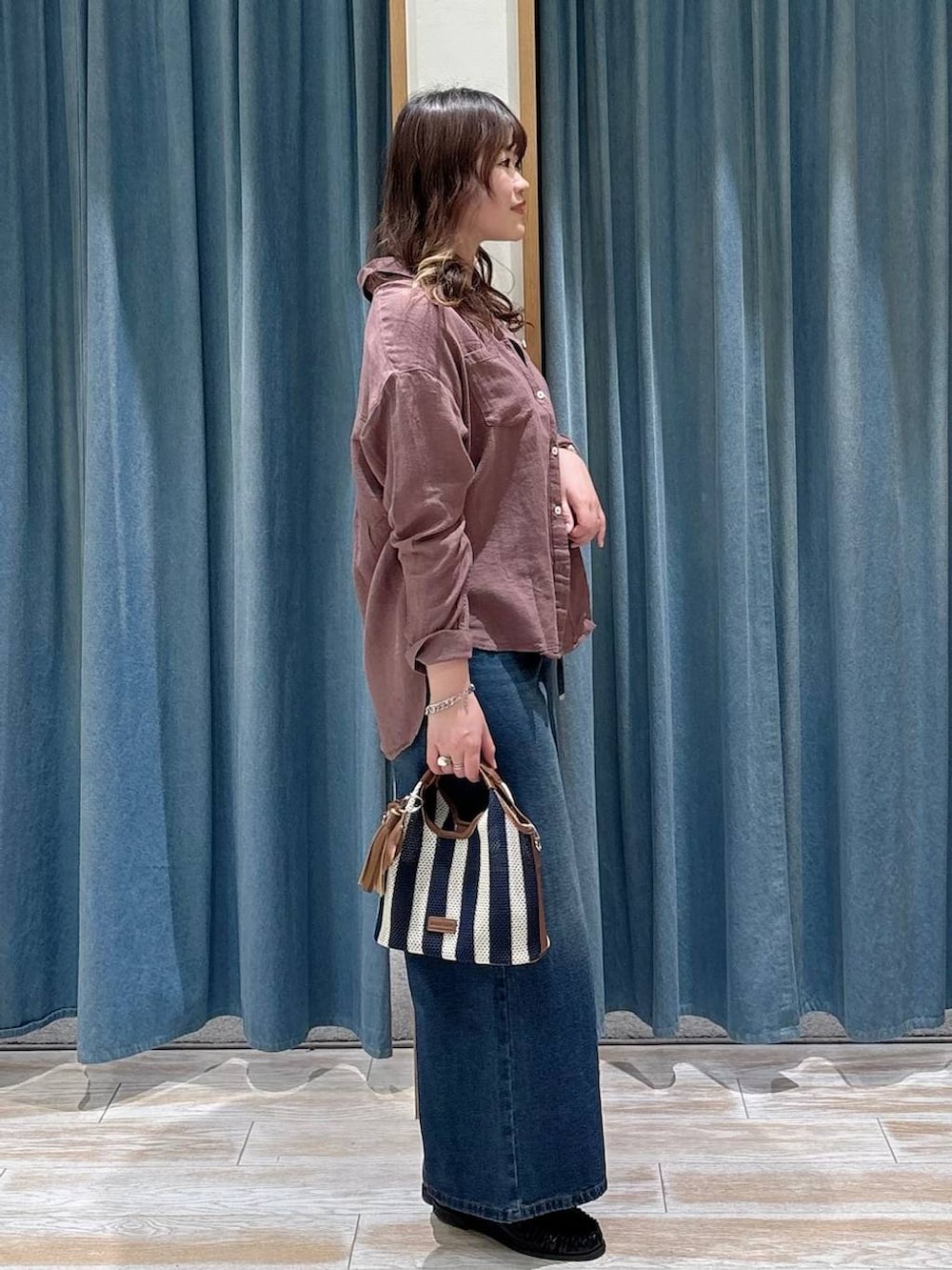 ブルー系のデニムパンツ、ブラック系のローファー、ブラウン系のシャツ/ブラウスを着用したレディースの春コーディネートの2枚目の写真