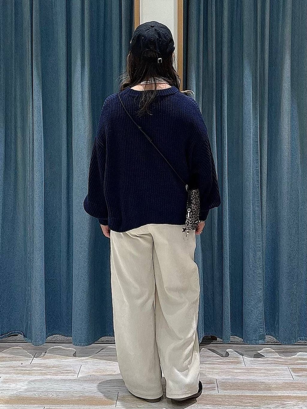 ブラウン系のショルダーバッグ、ブラック系のスニーカー、ホワイト系のその他パンツを着用したレディースの冬コーディネートの3枚目の写真