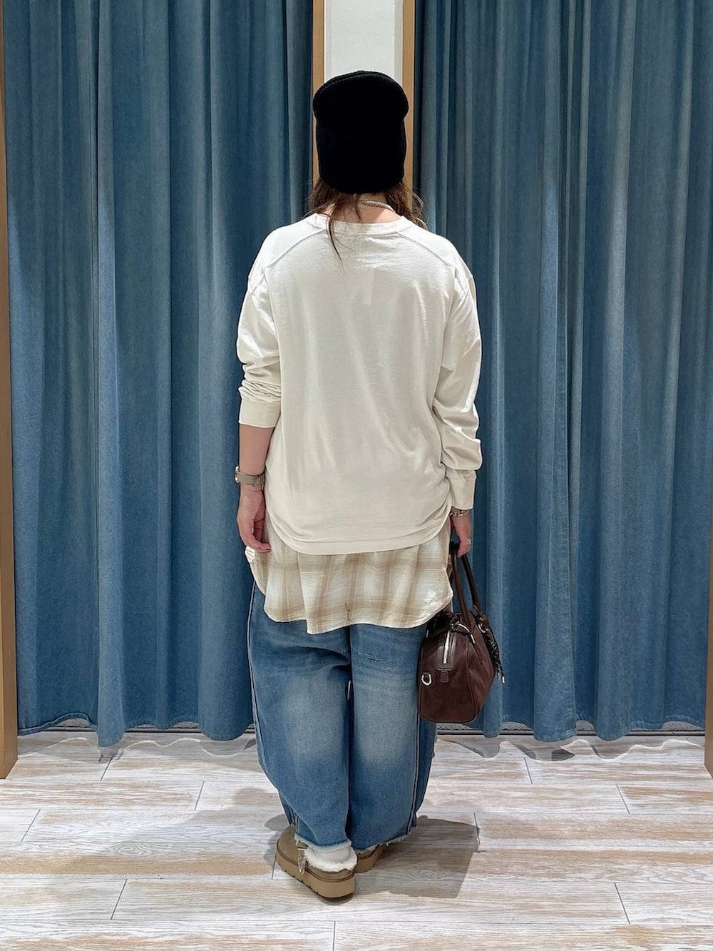 ベージュ系のその他シューズ、ブルー系のデニムパンツ、ブラウン系のハンドバッグを着用したレディースの秋コーディネートの3枚目の写真