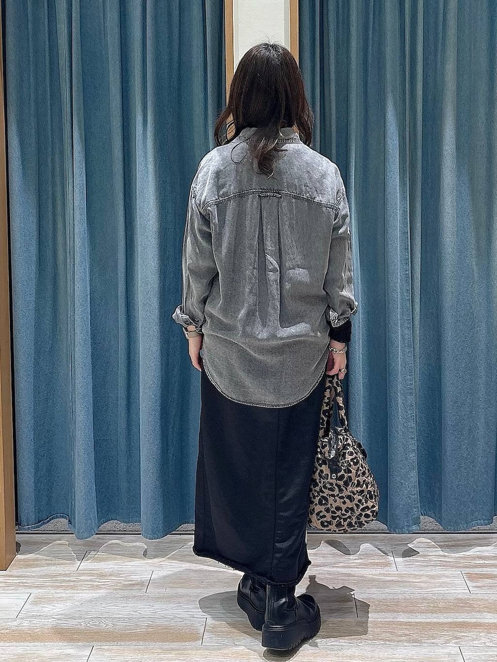 ブラック系のブーツ、ブラック系のTシャツ/カットソー、ブラック系のスカートを着用したレディースの冬コーディネートの3枚目の写真