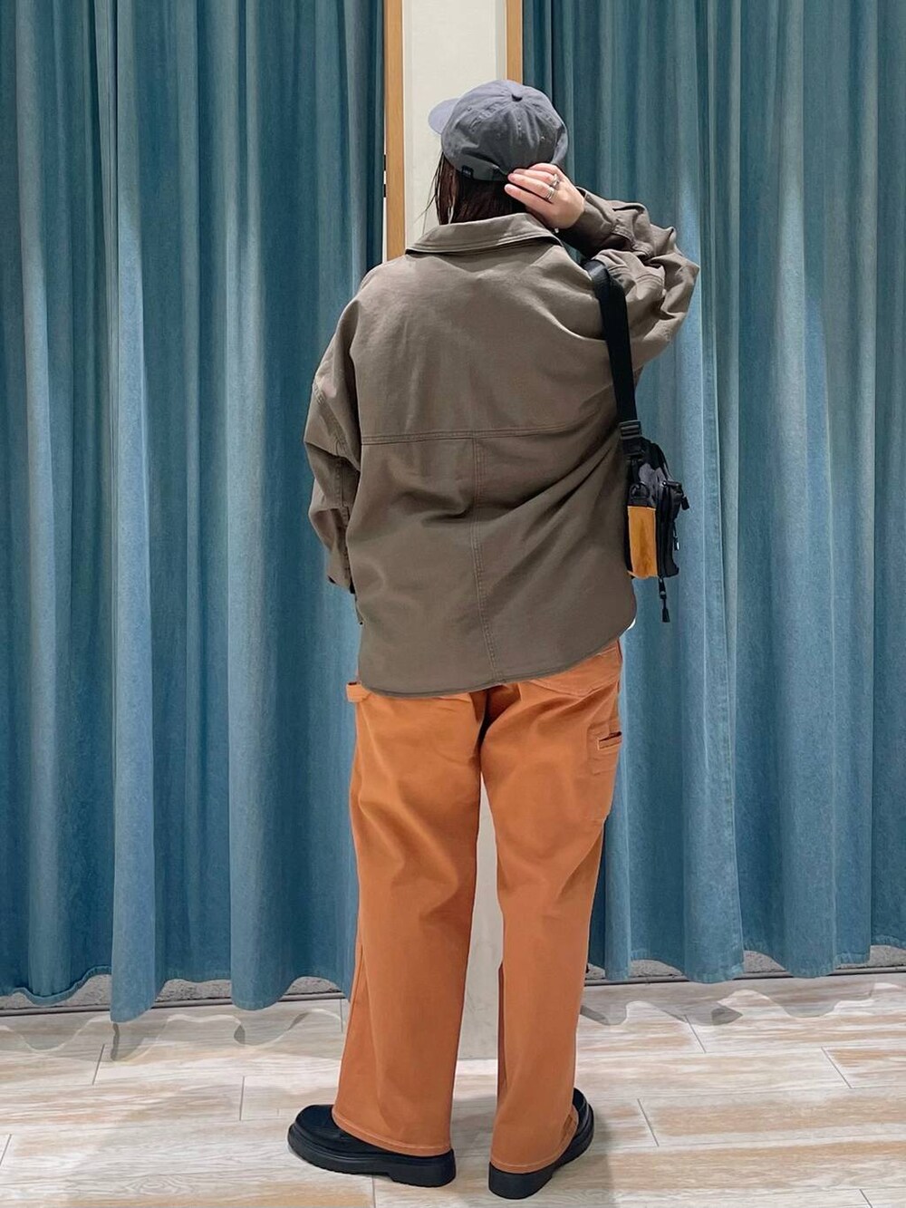 オレンジ系のその他パンツ、その他のローファー、ホワイト系のTシャツ/カットソーを着用したレディースの冬コーディネートの3枚目の写真