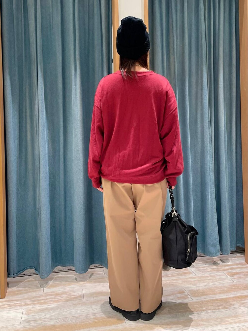 ブラック系のショルダーバッグ、ベージュ系のその他パンツ、レッド系のスウェットを着用したレディースの秋コーディネートの2枚目の写真