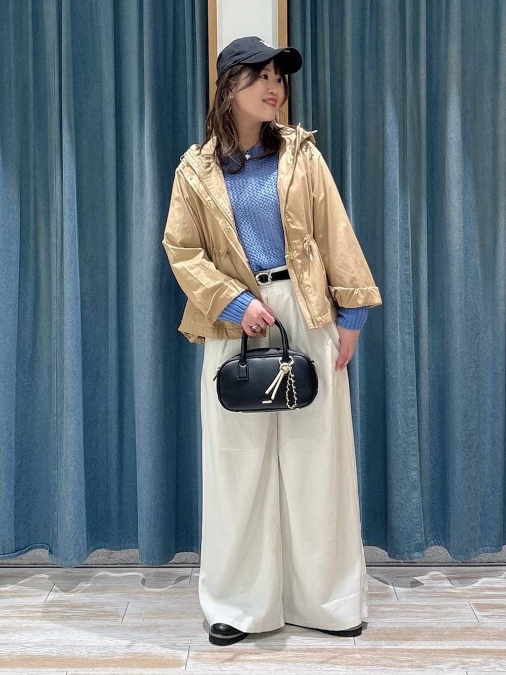 イエロー系のマウンテンパーカー、ブラック系のローファー、ブラック系のハンドバッグを着用したレディースの春コーディネートの4枚目の写真