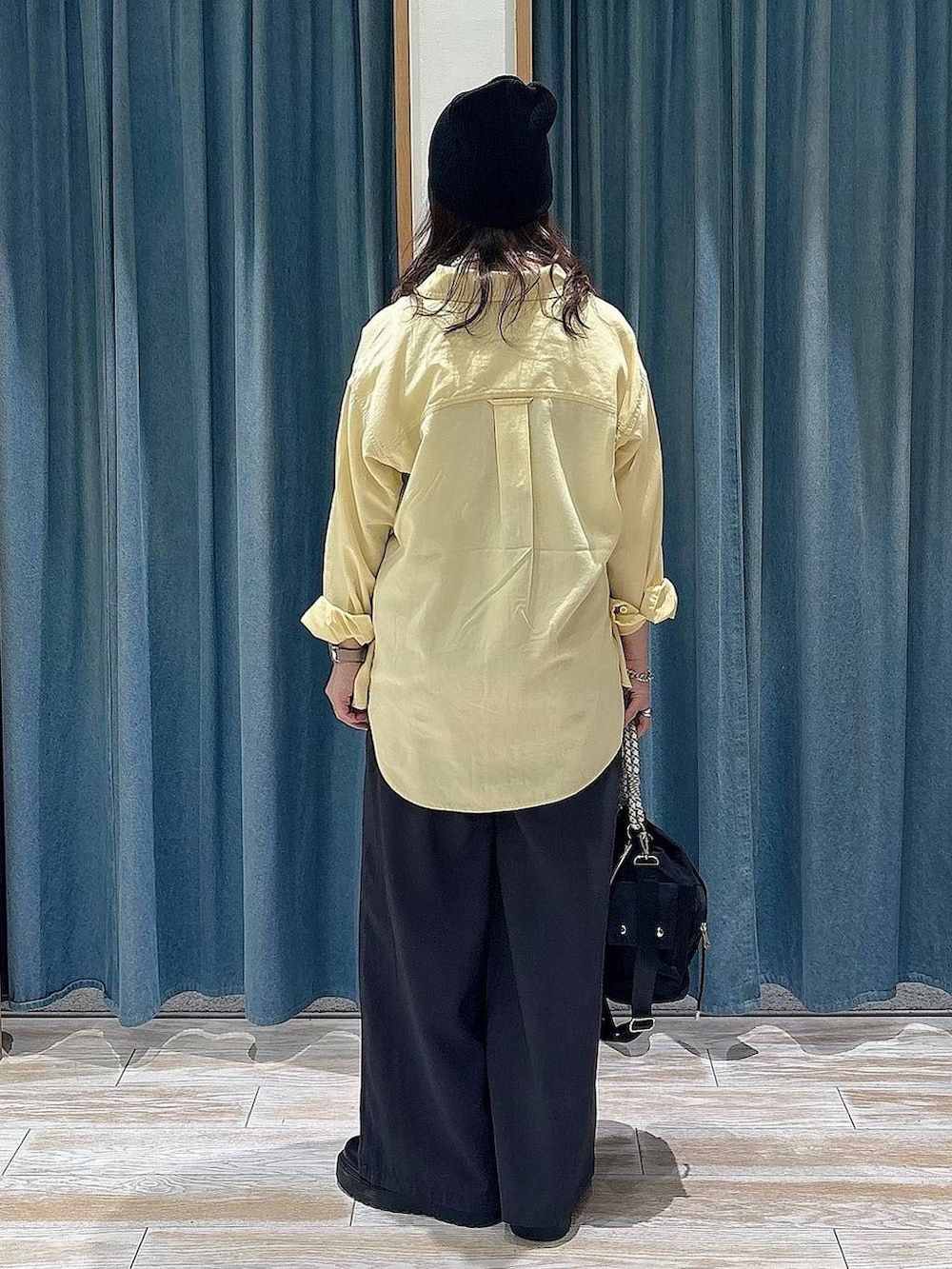 ブラック系のブーツ、ブラック系のハンドバッグ、イエロー系のシャツ/ブラウスを着用したレディースの冬コーディネートの3枚目の写真