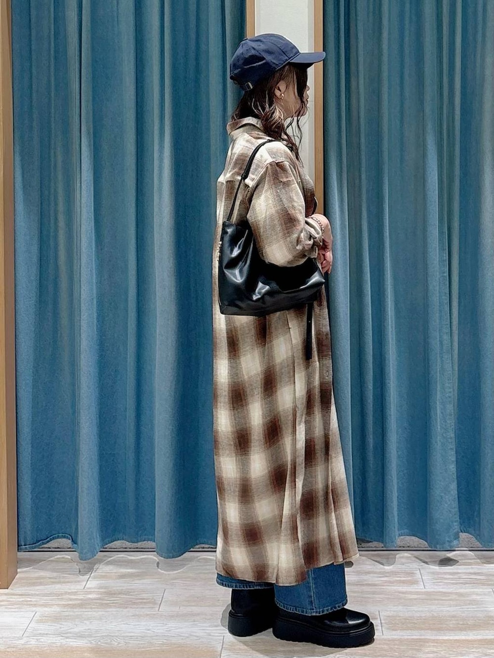 ブラック系のキャミソール、ブラック系のブーツ、ブラック系のハンドバッグを着用したレディースの秋コーディネートの2枚目の写真