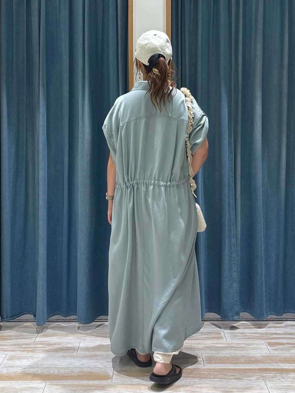 ベージュ系のその他パンツ、ブラック系のサンダル、ホワイト系のショルダーバッグを着用したレディースの夏コーディネートの3枚目の写真