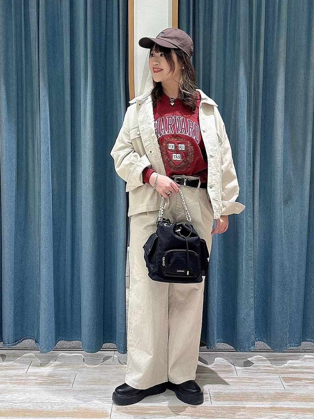 ブラック系のブーツ、ブラック系のハンドバッグ、レッド系のスウェットを着用したレディースの冬コーディネートの4枚目の写真